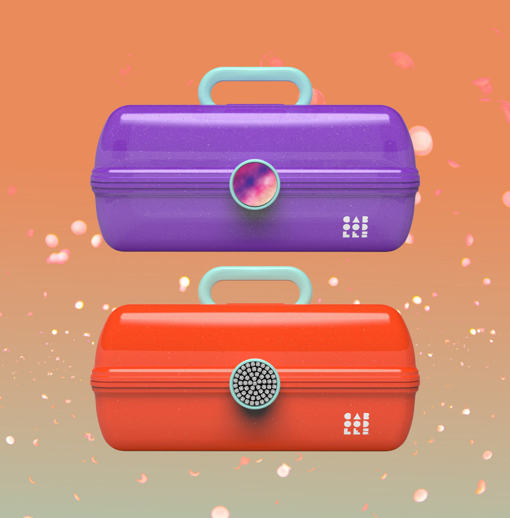 Two colorful makeup cases, one purple and one red, on a gradient background.